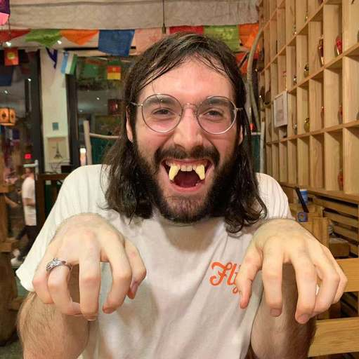 A picture of me with milk treats in my mouth that look like fangs, pretending to be a vampire.